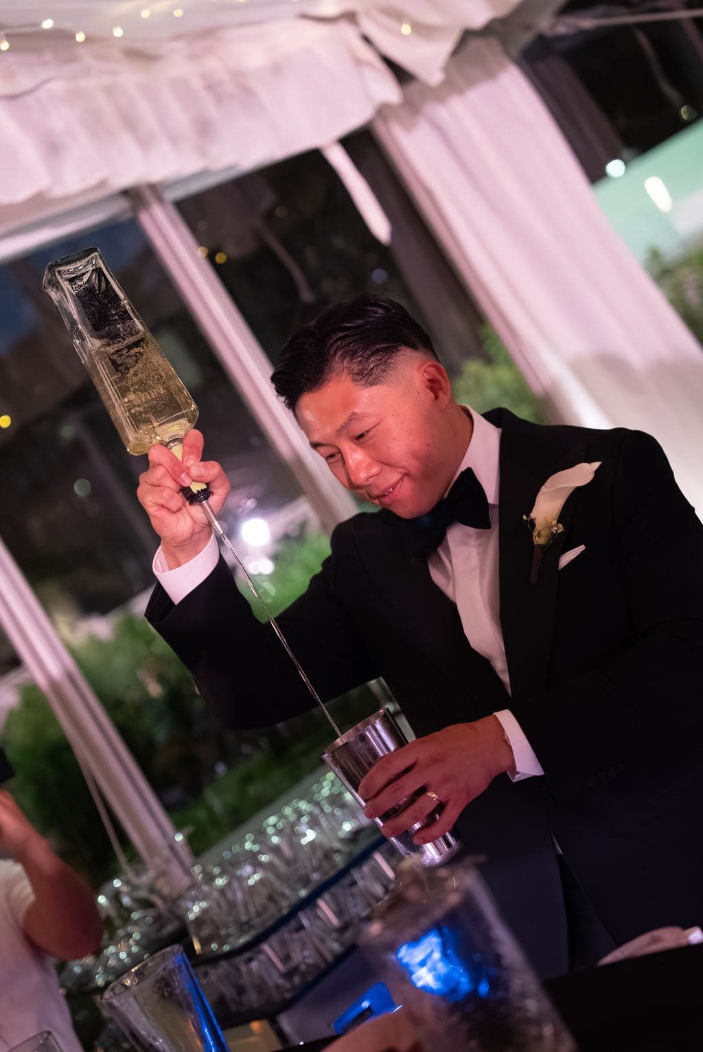 A bartender pouring a flair cocktail at an event bar