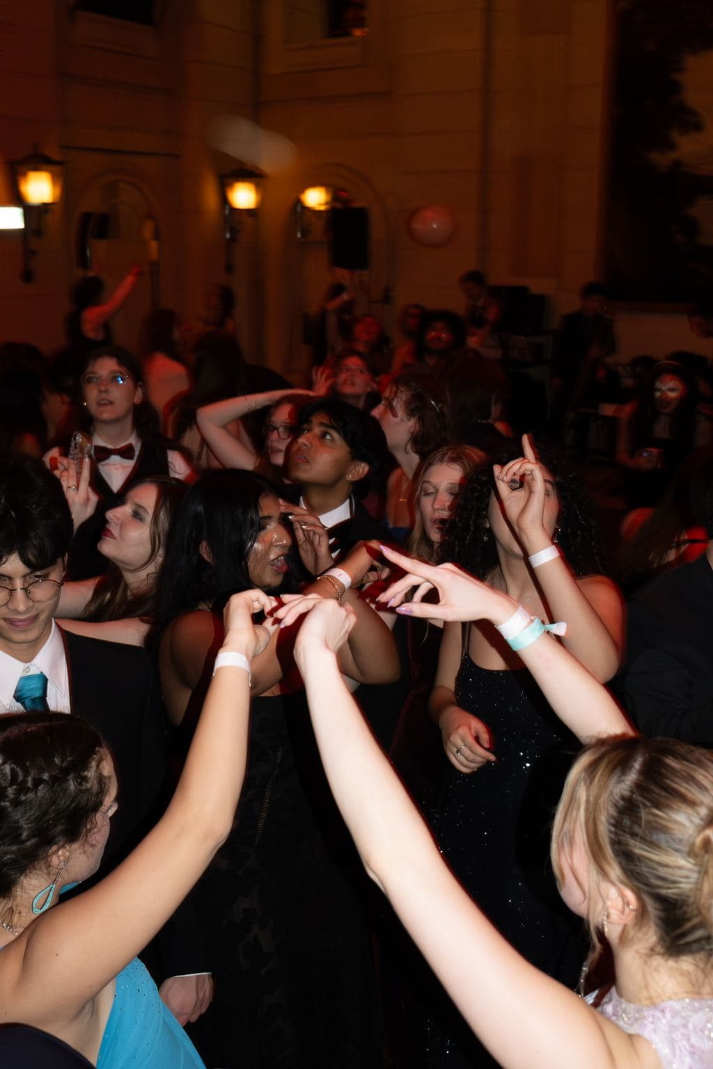 Guests reaching up as balloons fall in a grand ballroom