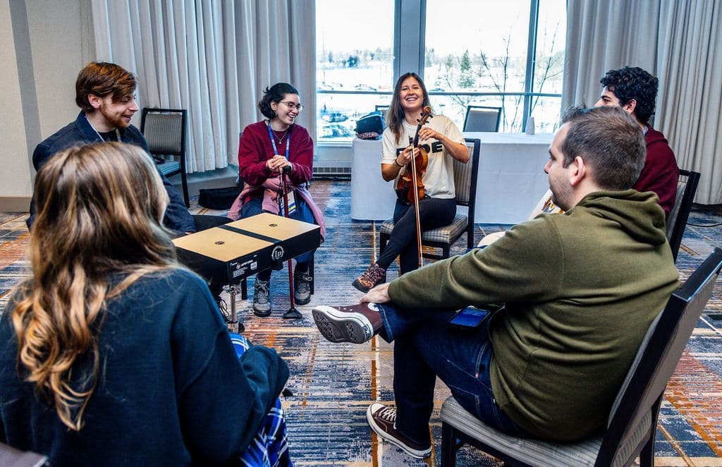 Musicians playing violin and hand drum in an impromptu circle