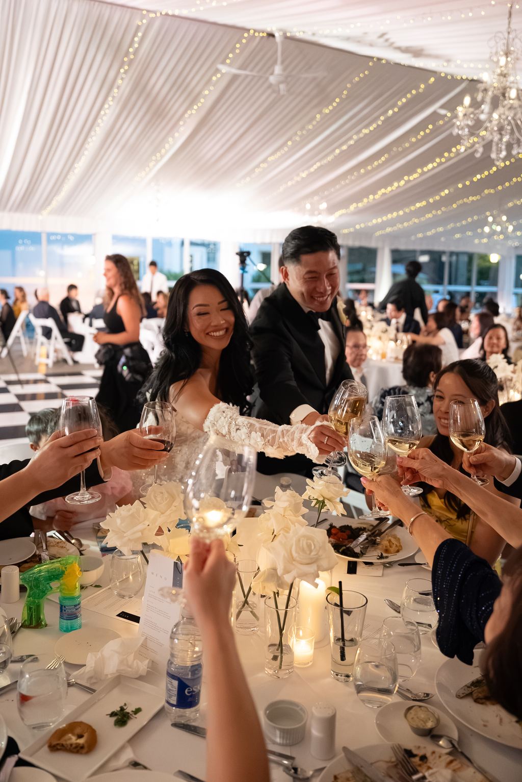 Guests raising a toast together at a candlelit reception table