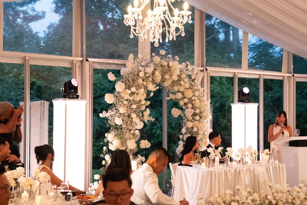 Reception room with a floral arch, crystal chandelier and floor-to-ceiling windows