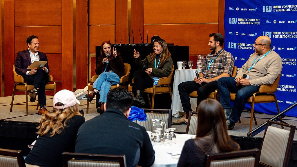 A five-person panel discussion on stage at the LEV Elevate Conference & Shabbaton