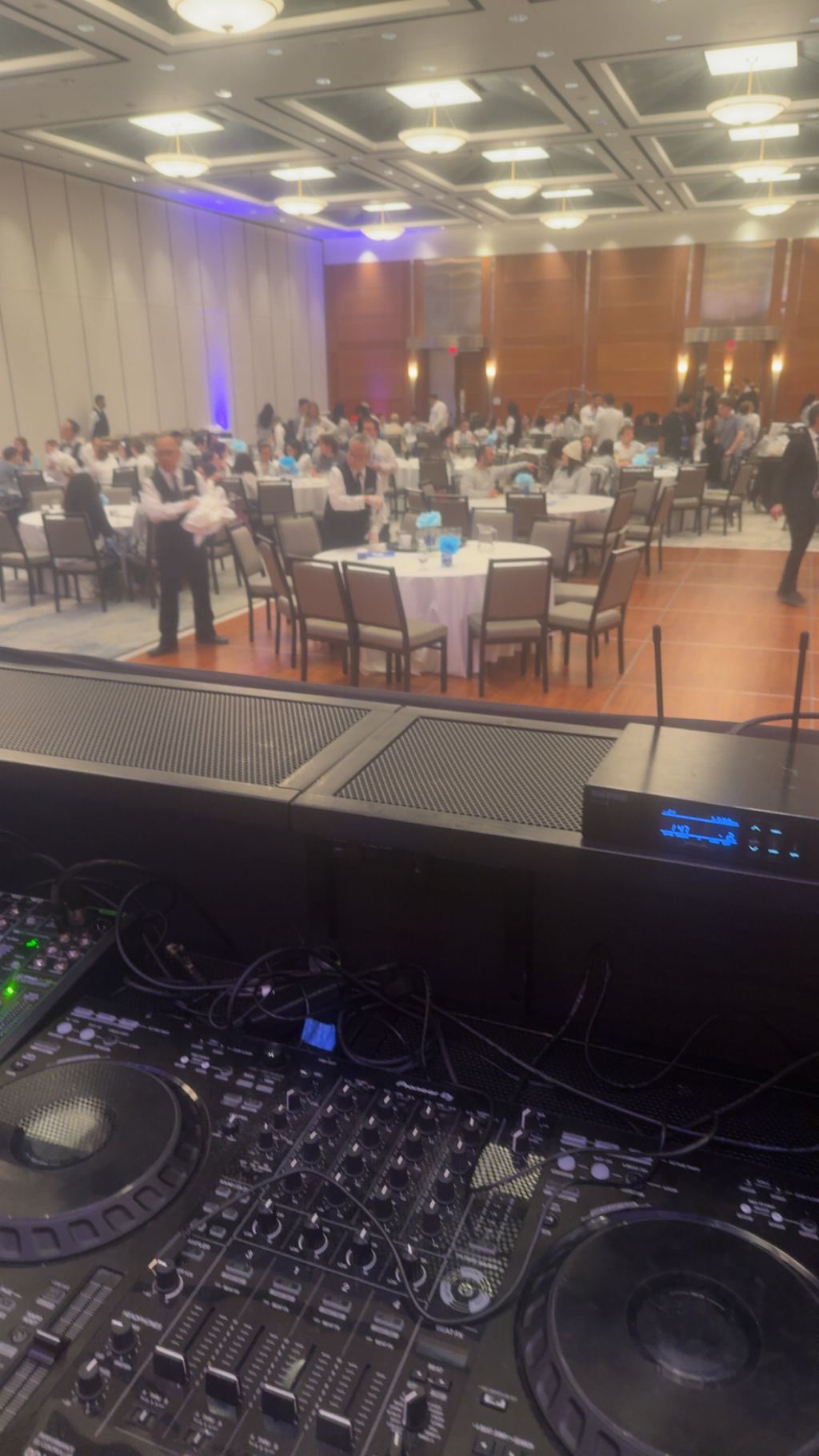Ballroom being set for dinner, seen past the AV booth