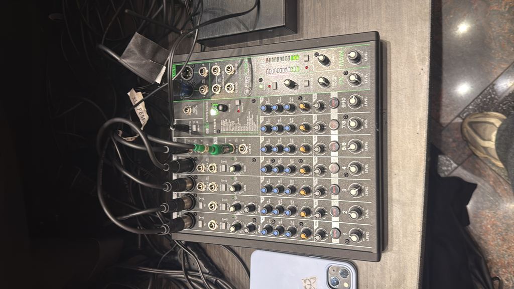 Close-up of an audio mixing board mid-event