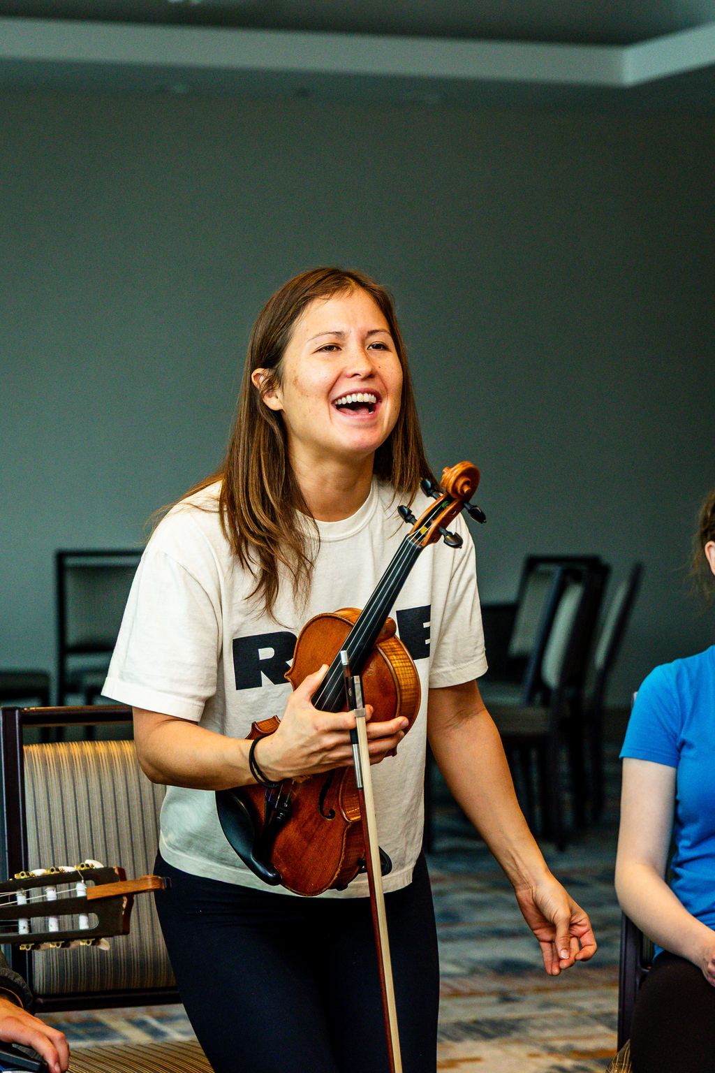 A violinist laughing mid-performance